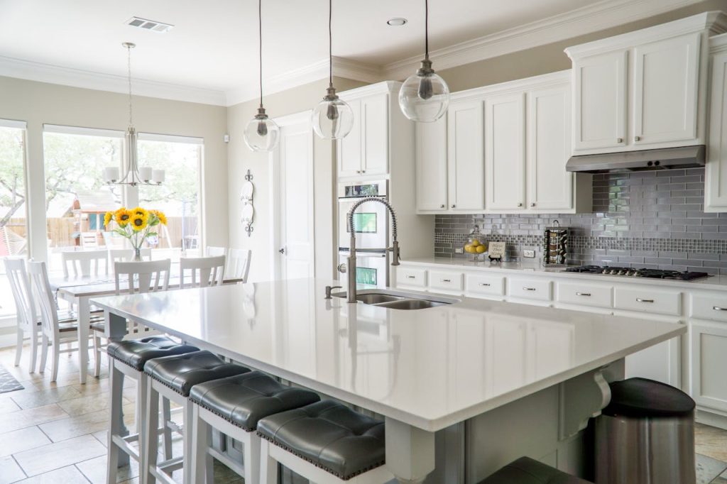 pexels photo 1080721 Spacious modern kitchen with white cabinets and island in natural light.